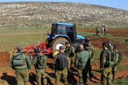 جنود الاحتلال يراقبون فلسطينيين يحرثون أرضهم في الضفة الغربية المحتلة )