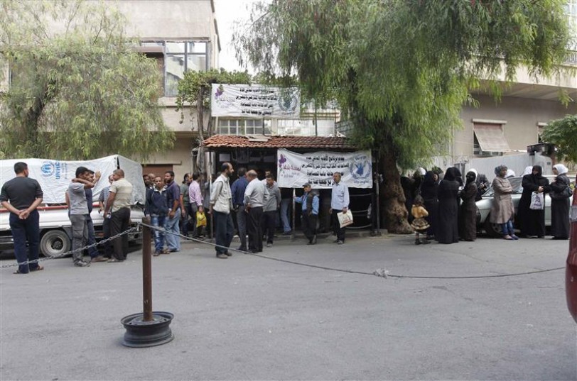 سوريون ينتظرون للحصول على مساعدات امام مركز للامم المتحدة في دمشق امس (رويترز)